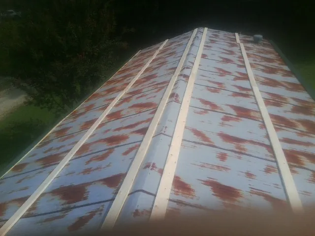 Rusted metal roof panels with new wood purlins before replacement — Storm Damage Roof Repair in Windsor Mill by Roofing Brothers
