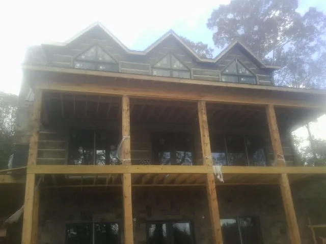 Dormers and porch framing on a large log home under construction — Roof Coating work by our crew in Windsor Mill