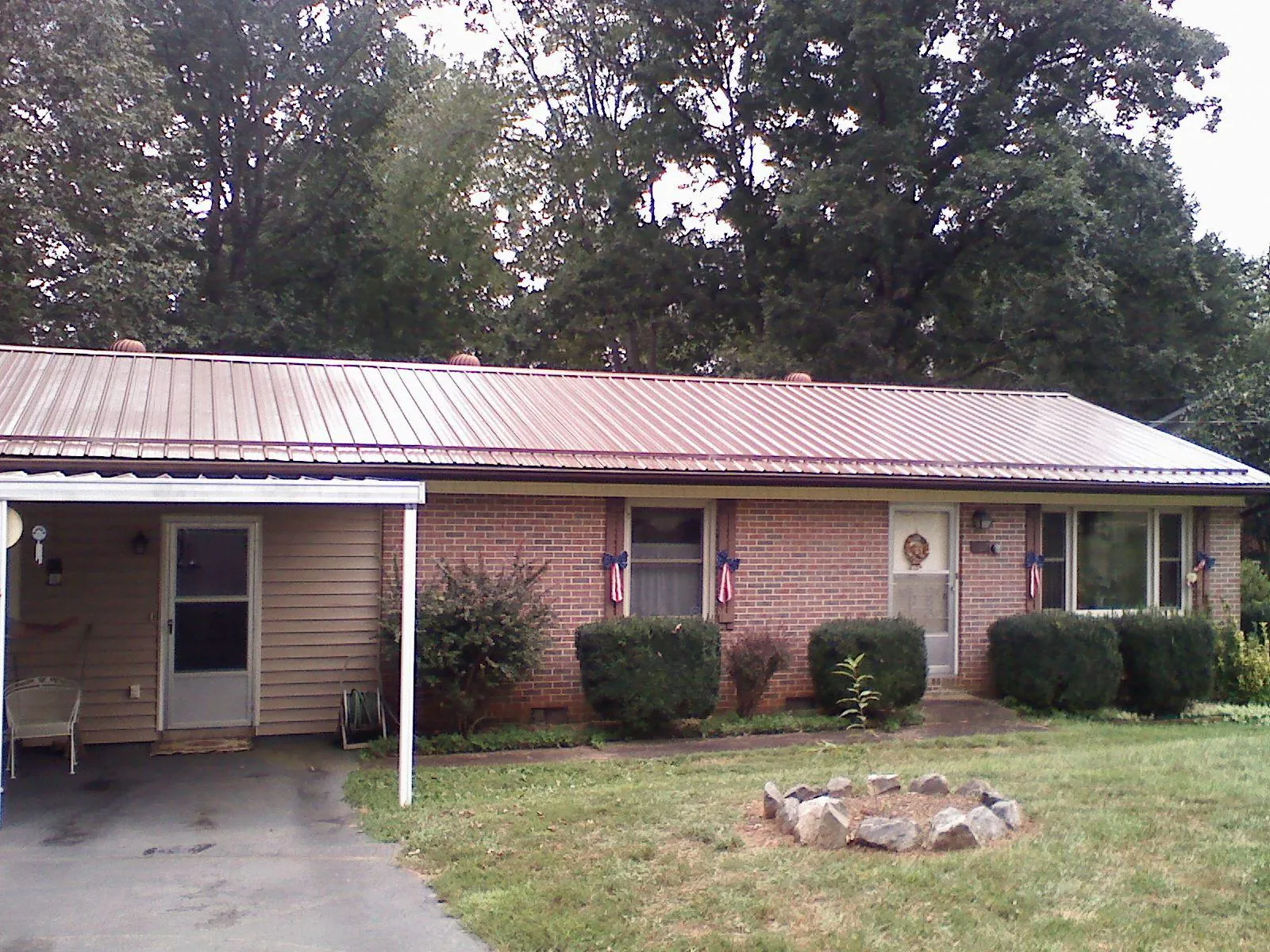 Bronze metal roof and carport on a brick ranch home — Roof Repair work by our crew in Windsor Mill